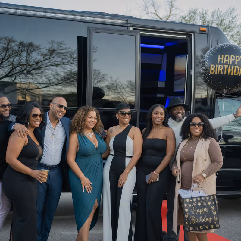 Group boarding a white charter bus for Birthday Transportation transportation in Coral Gables