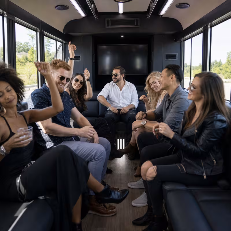 Group boarding a white charter bus for Concert Transportation transportation in Coral Gables