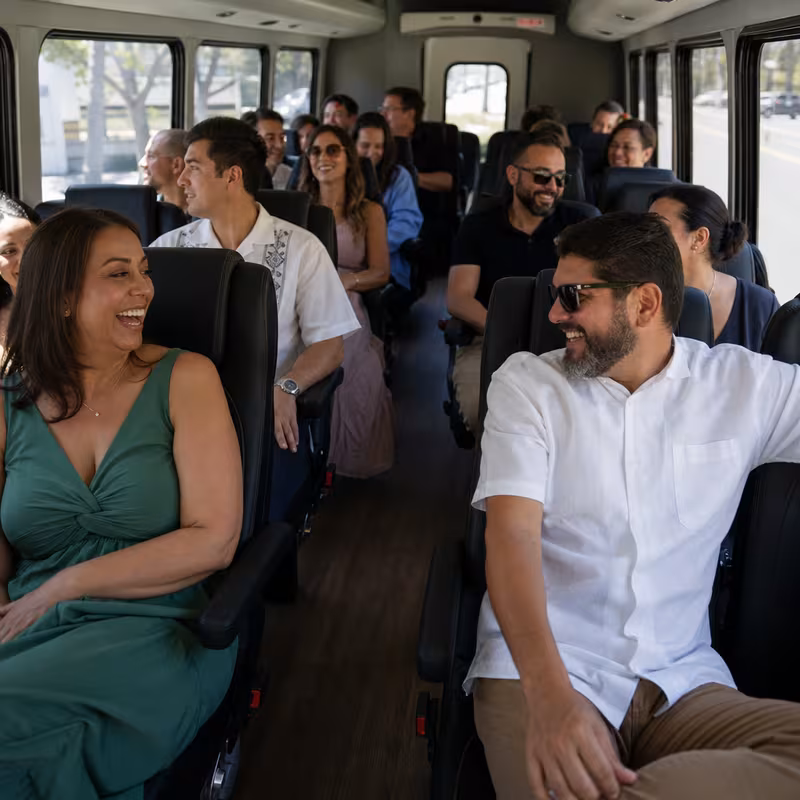 Group boarding a white charter bus for Private Event Transportation transportation in Coral Gables