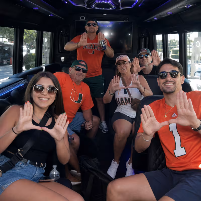 Group boarding a white charter bus for Sporting Event Transportation transportation in Coral Gables