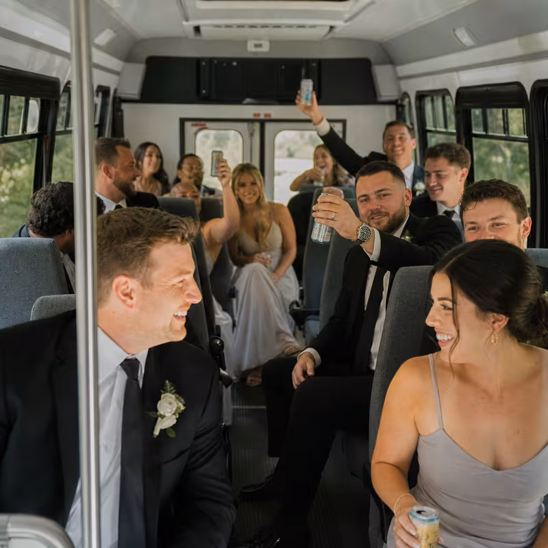 Group boarding a white charter bus for Wedding Transportation transportation in Coral Gables